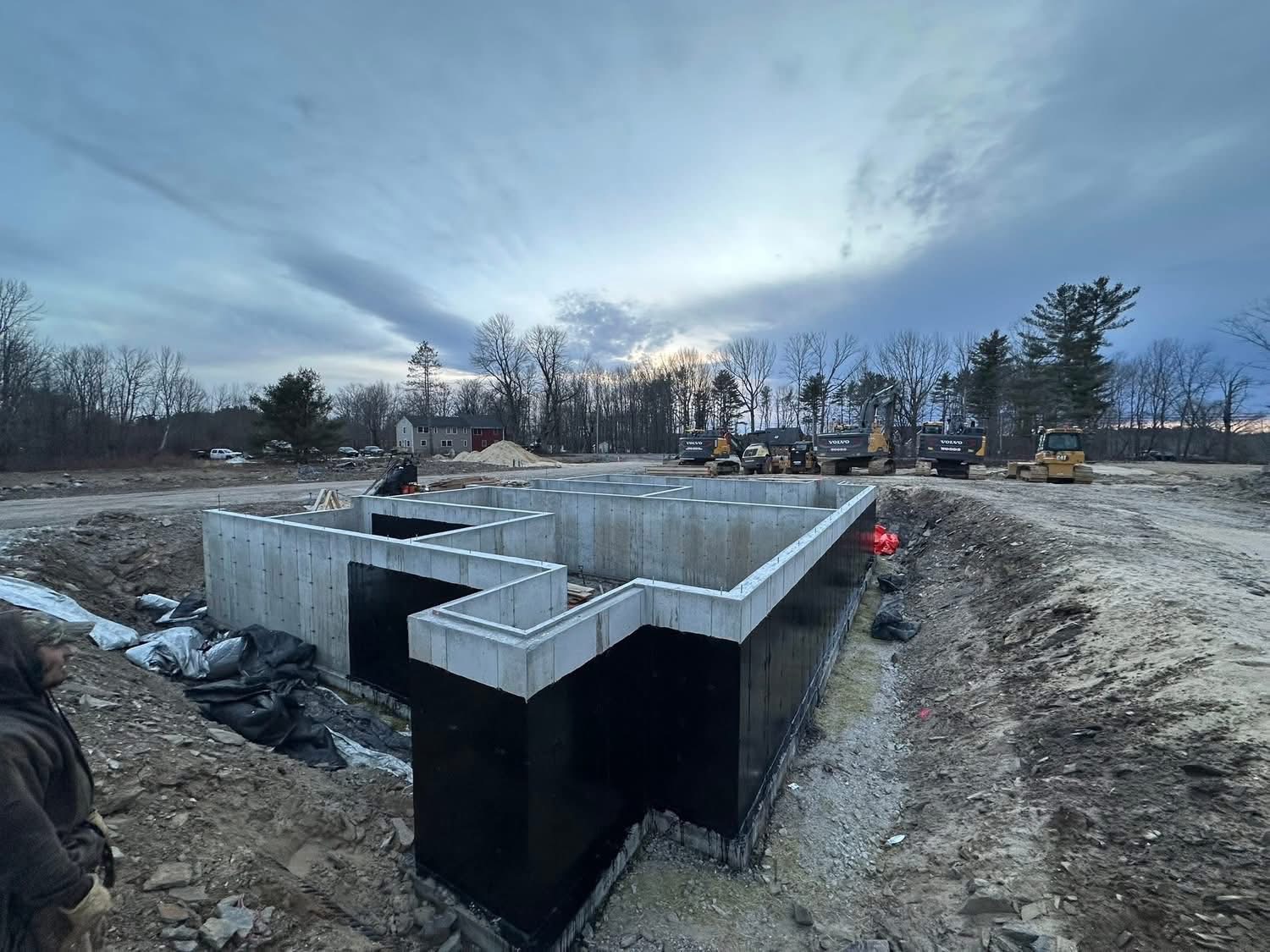 Large foundation site with multiple wall sections and construction equipment