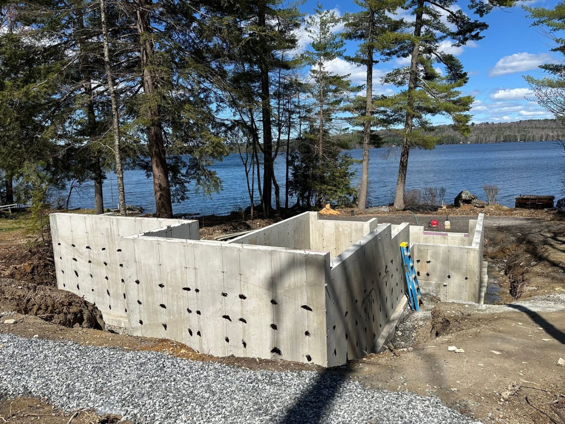 Lakefront foundation with fresh black waterproof coating in Southern Maine