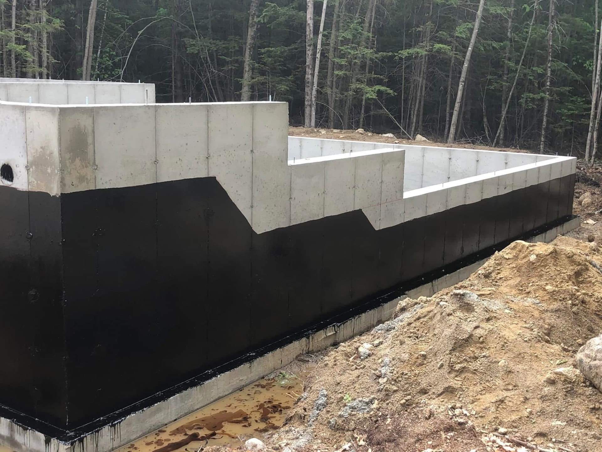 Poured foundation walls with heavy black waterproof membrane coating
