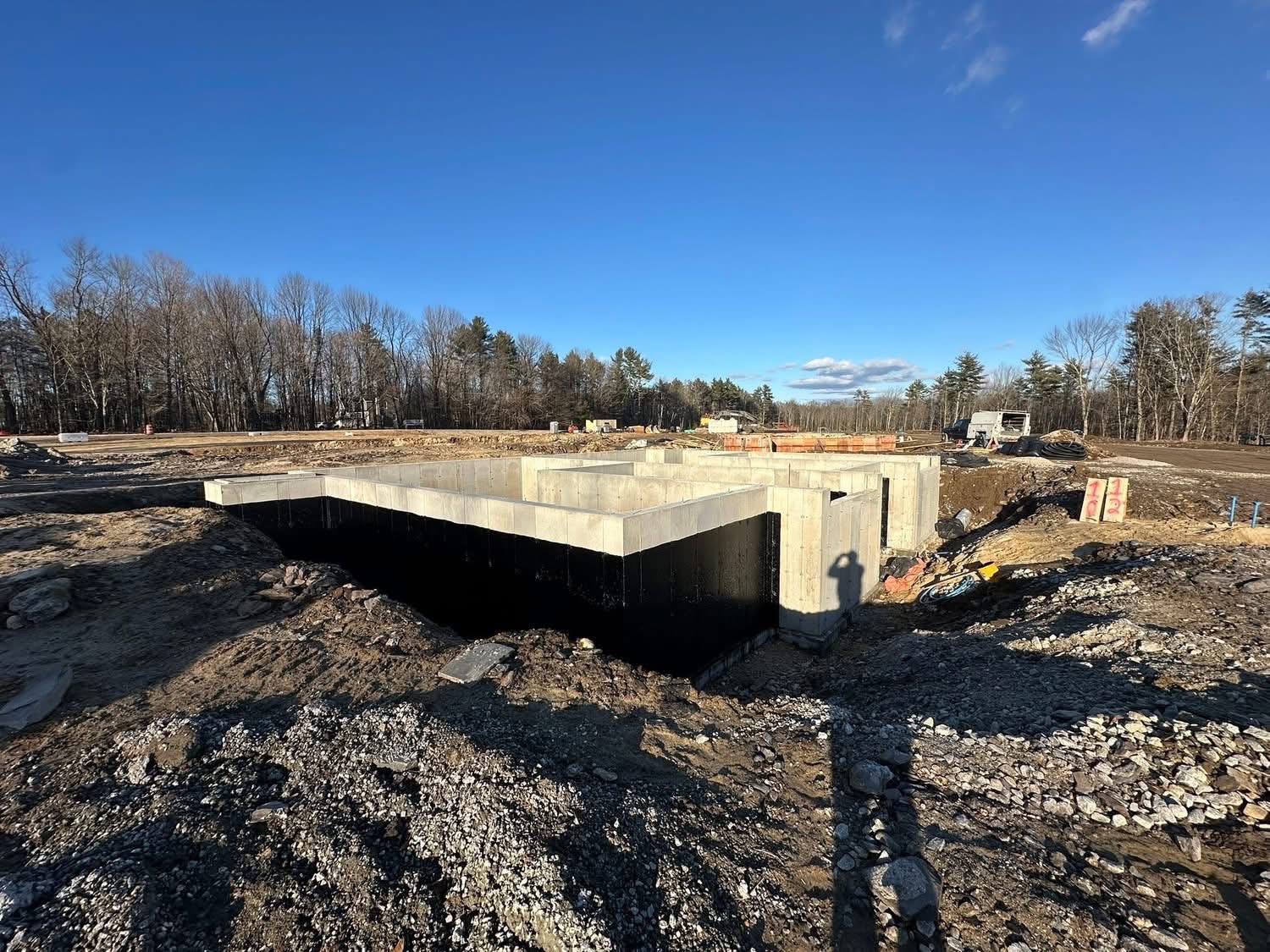 Wide view of a large foundation footprint with black waterproofing applied